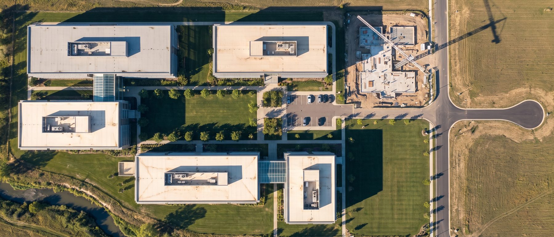 A top-down aerial view of a life sciences research park, one parcel under construction.